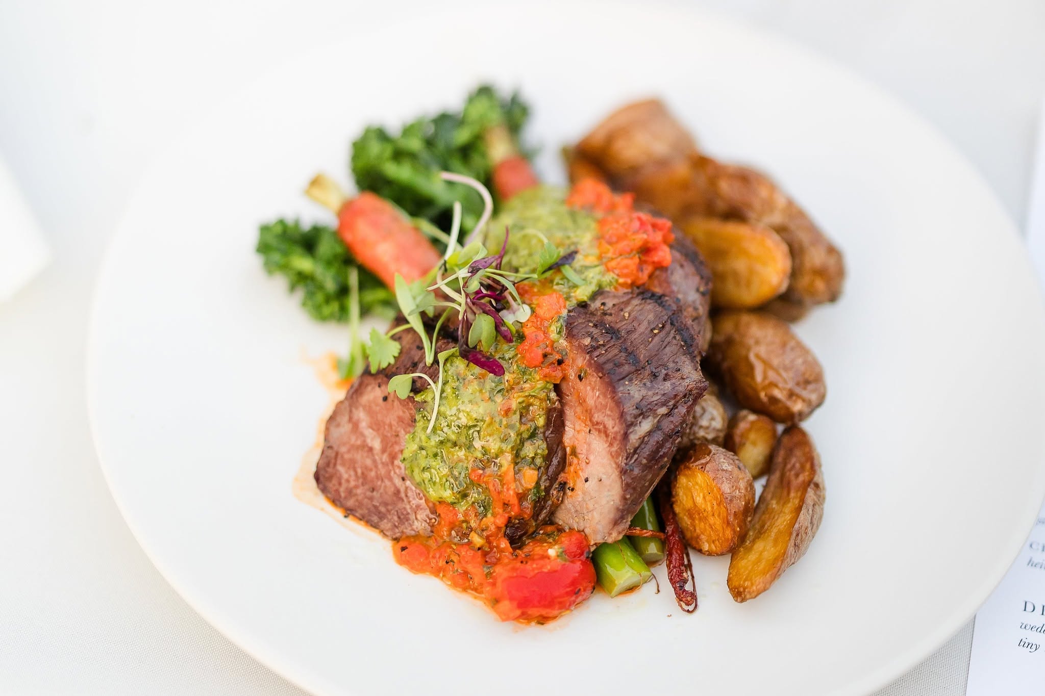 Plated gala dinner — grilled and smoked beef medallions with charred broccolini and heirloom carrots